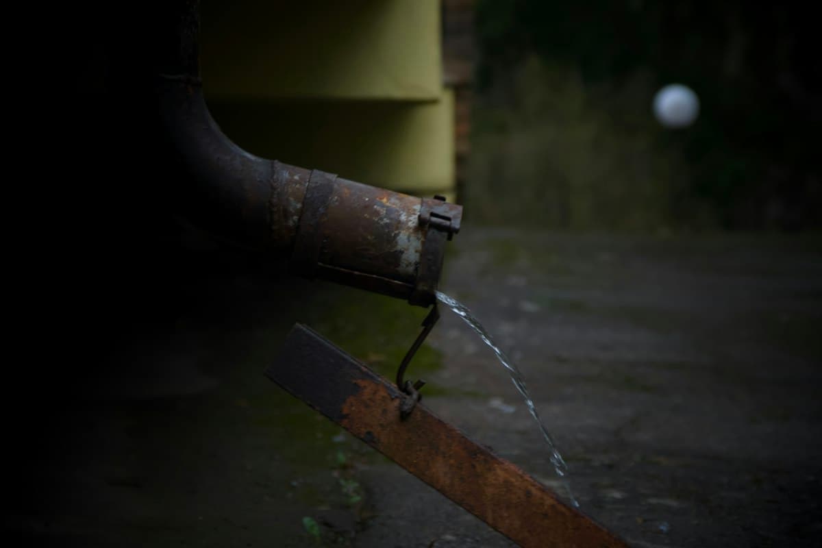 Water dripping from a leaking downpipe outlet