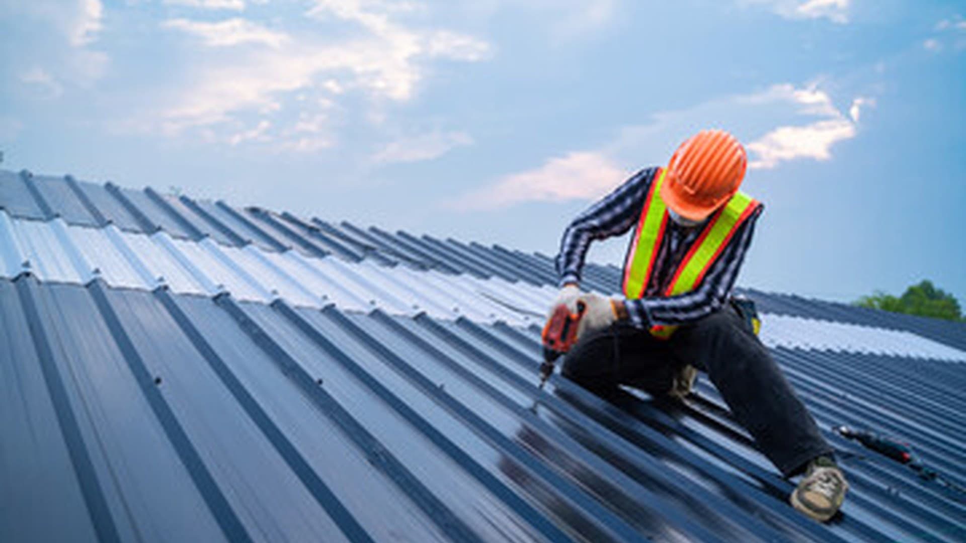 Roofer fixing a new metal roof