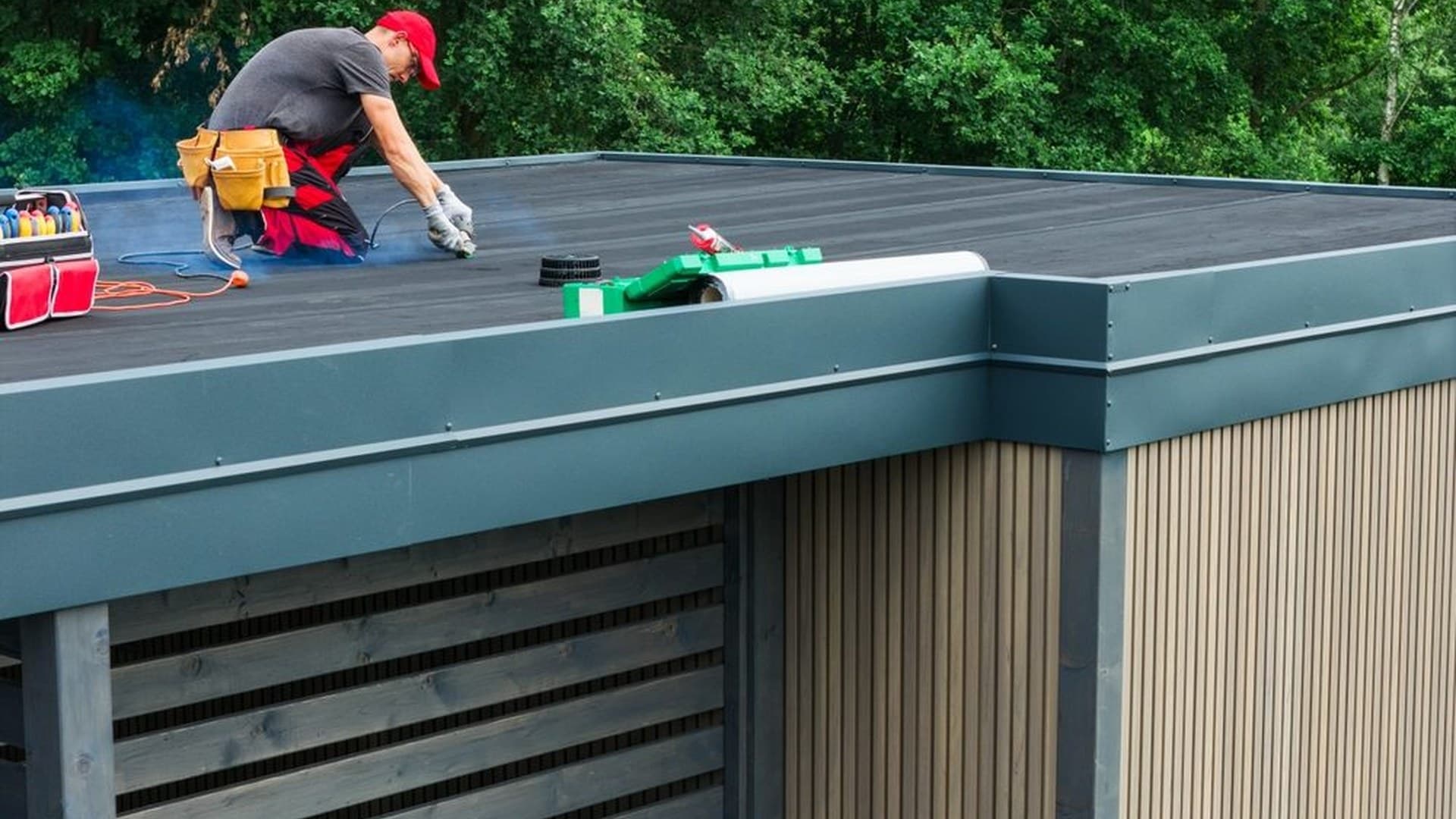 Roofer finishing a new flat roof on an extension