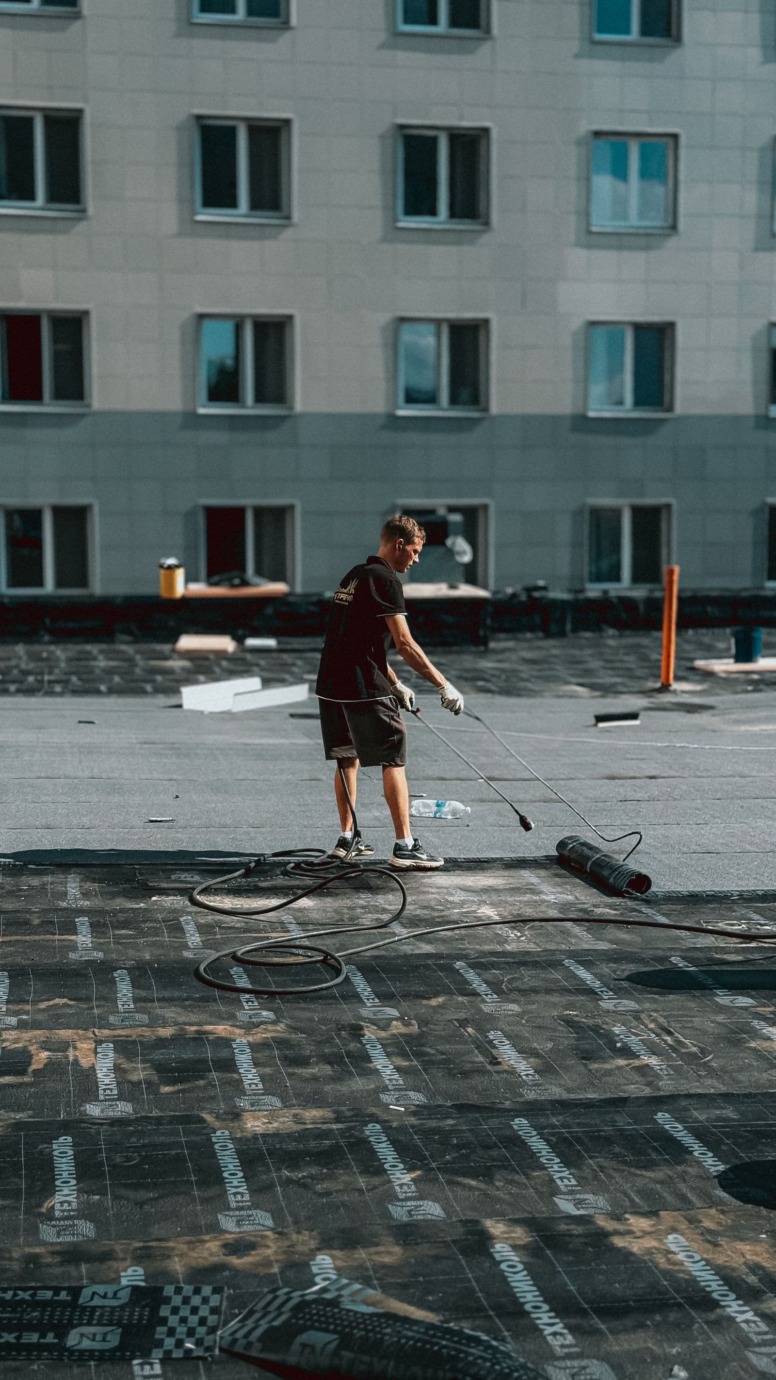 Roofer working across a large flat roof