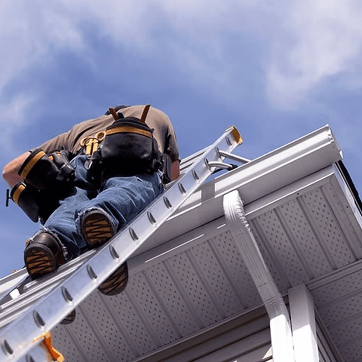 Installer fitting new guttering from a ladder
